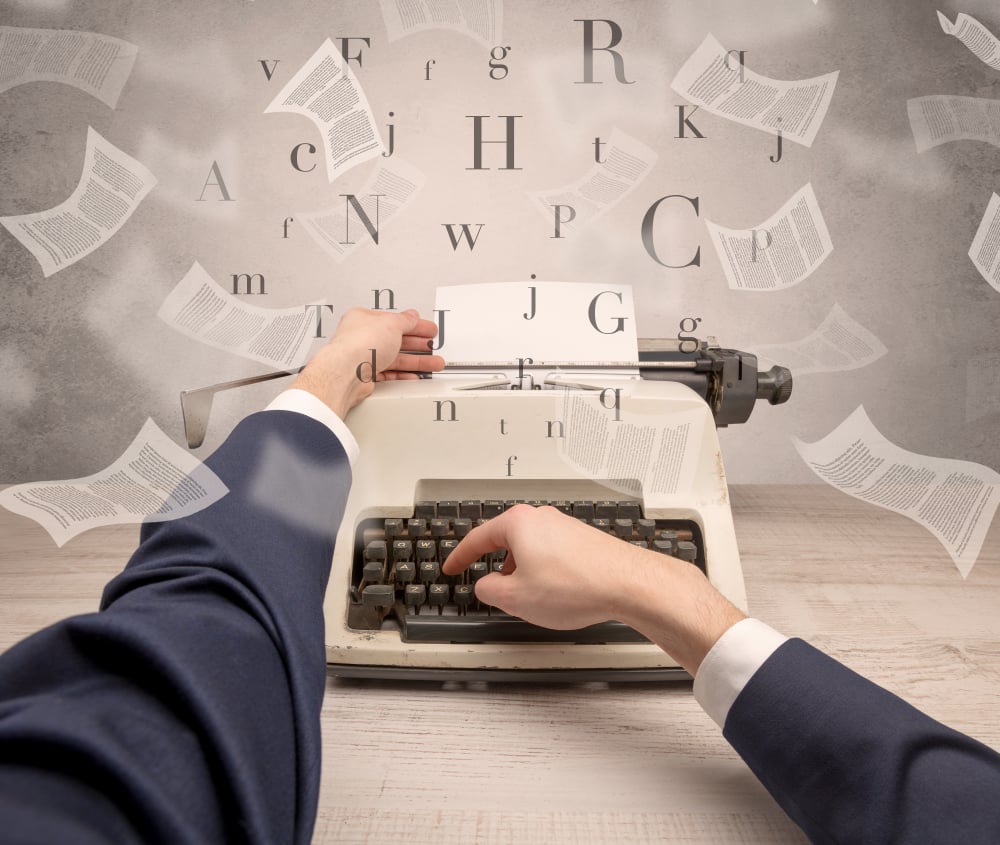 A man sitting in front of a typewriter with letters floating above it