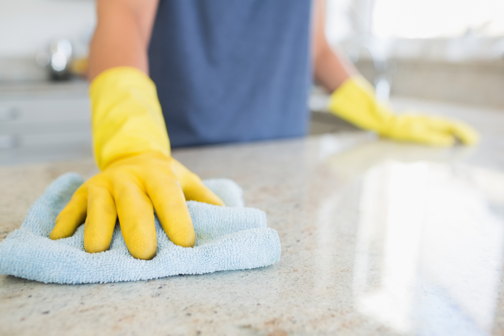 A person wearing latex gloves, holding a rag