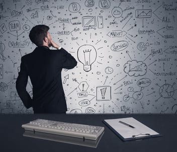A man holding his chin as he looks at a wall of ideas