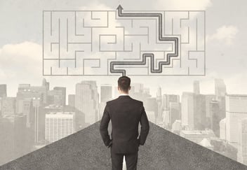 A man looking at a maze that has the path to the goal highlighted
