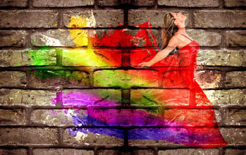 Colorful image of a woman across a brick wall