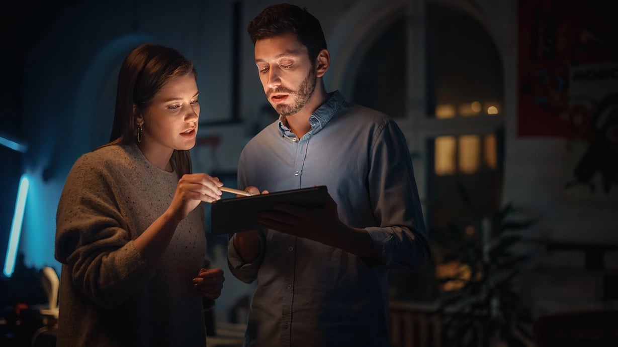 Two coworkers looking at data on a tablet